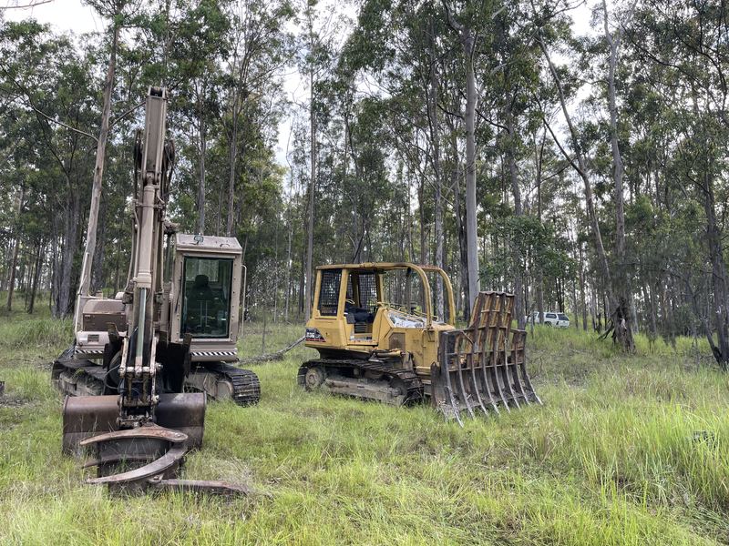 Komatsu PC130 excavator and Caterpillar D3G dozer with stick rake clearing on a rural property
